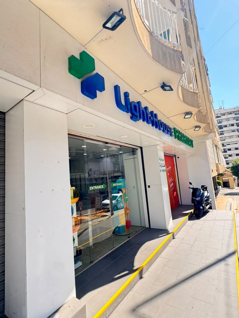 Light House Pharmacy storefront with its green and blue cross sign on Ardati Street, Manara